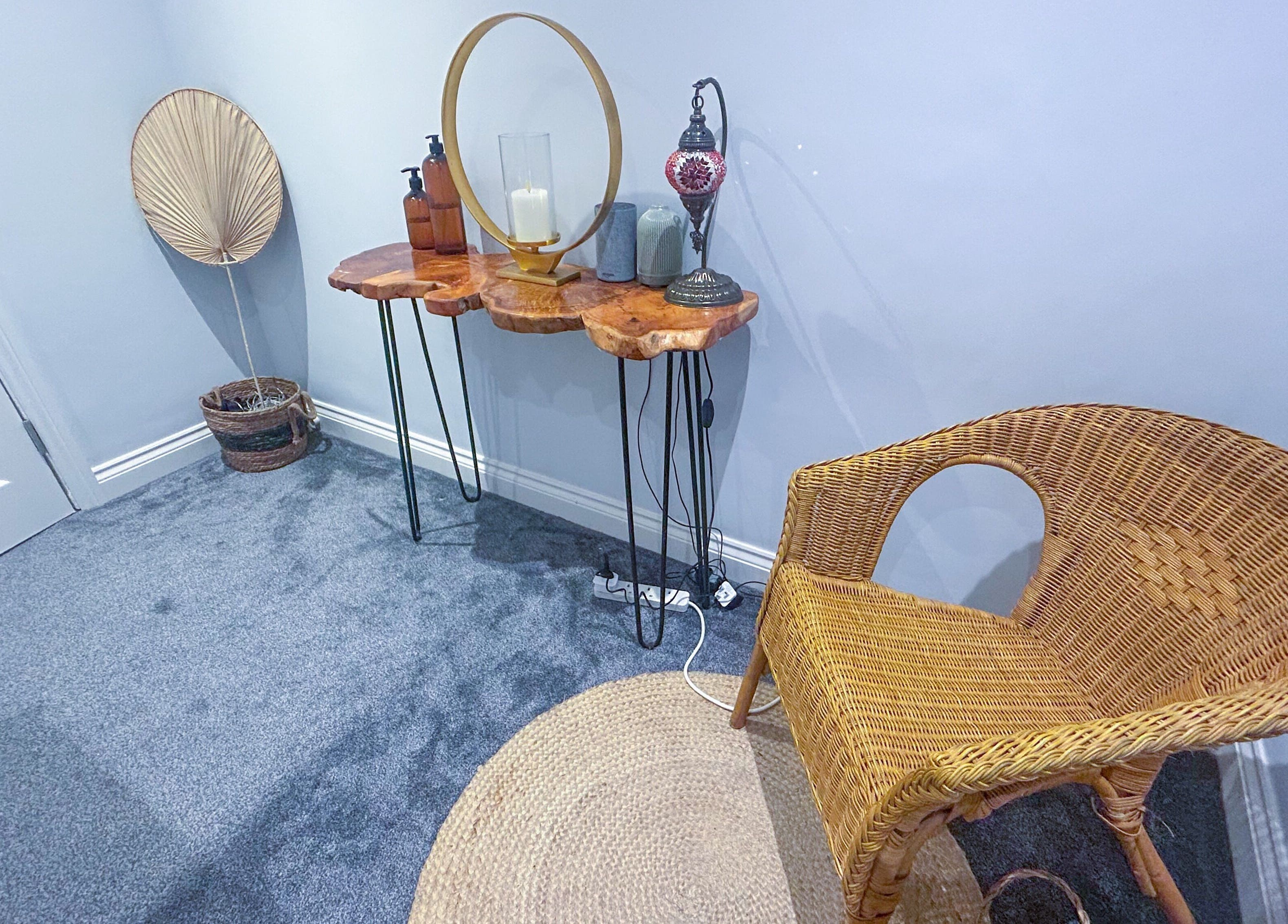 Stylish therapy room with wicker chair and decor at Leme Personal Therapy, London, England, GB.