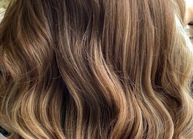 Elegant wavy hairstyle at The Hair Cabin, Cambridge, England, GB. Perfect blend of tones for a chic look.
