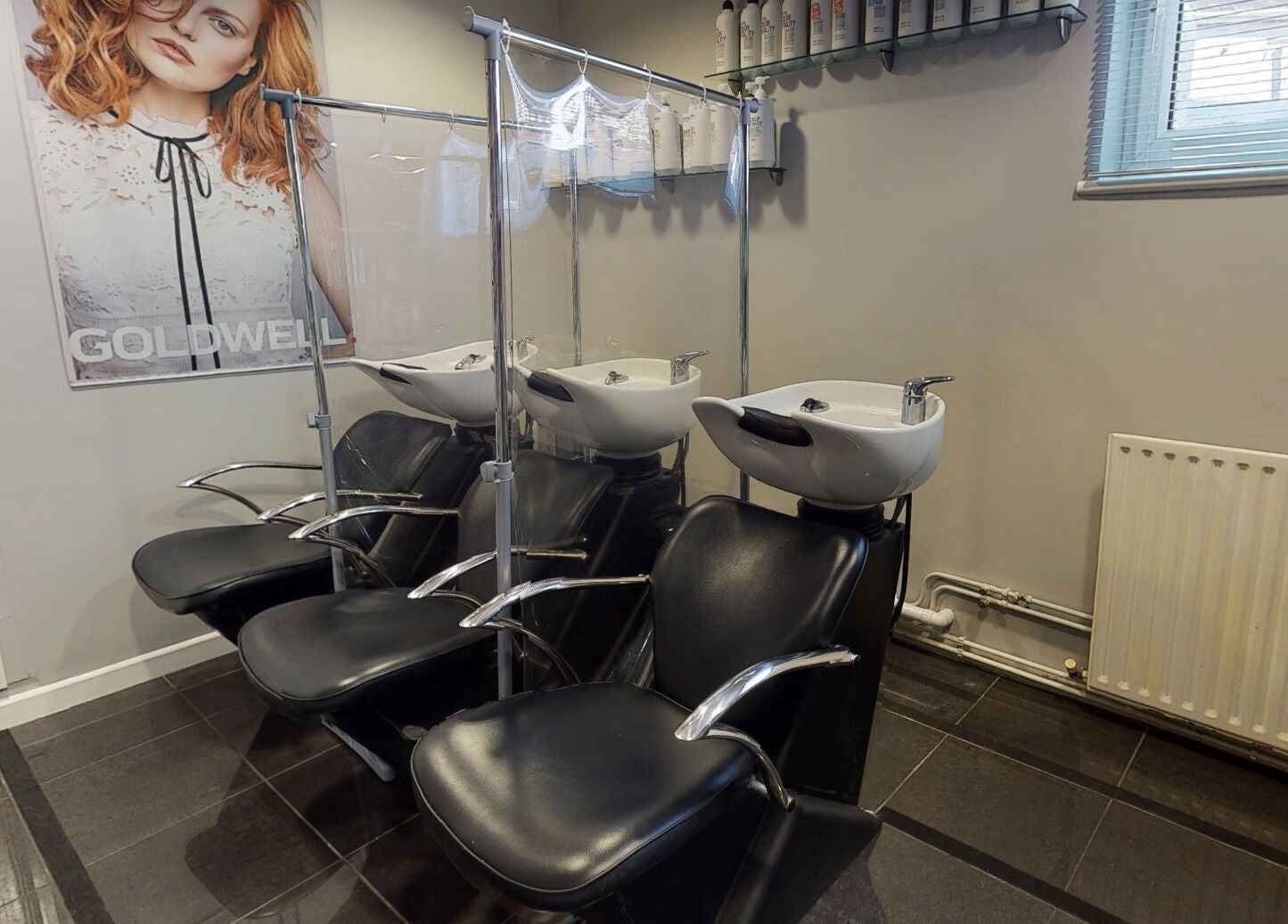 Modern wash station at Jonathan Ditton Salons, Emsworth, England, GB, with sleek black chairs and shampoo basins.