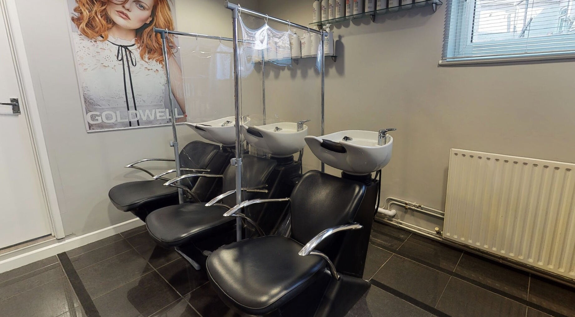Modern wash station at Jonathan Ditton Salons, Emsworth, England, GB, with sleek black chairs and shampoo basins.