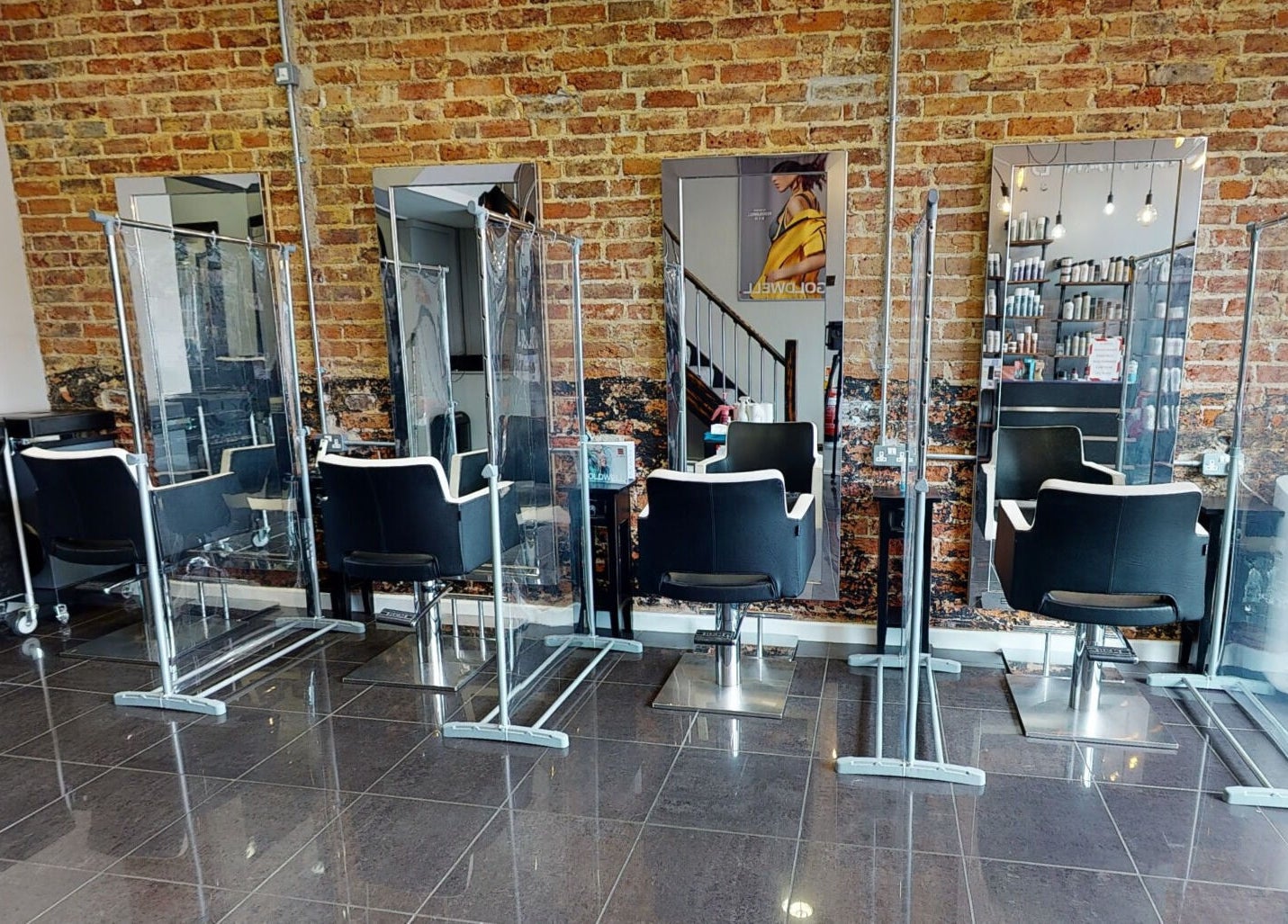 Modern salon chairs and mirrors at Jonathan Ditton Salons, Emsworth, England, GB. Stylish brick wall interior.