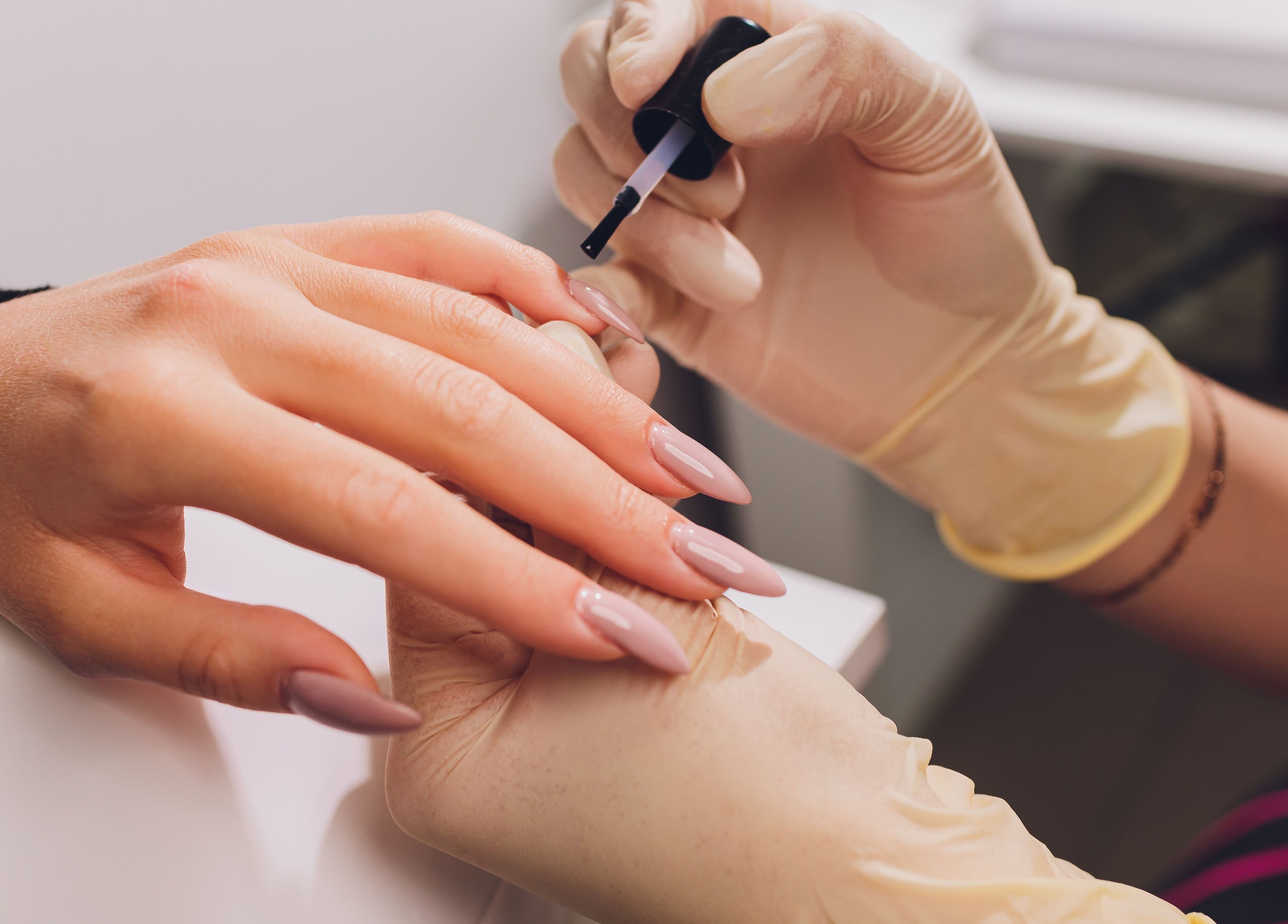 Nail technician applying polish at Auva Nails Home Service in Abu Dhabi, AE. Perfect for a polished finish.