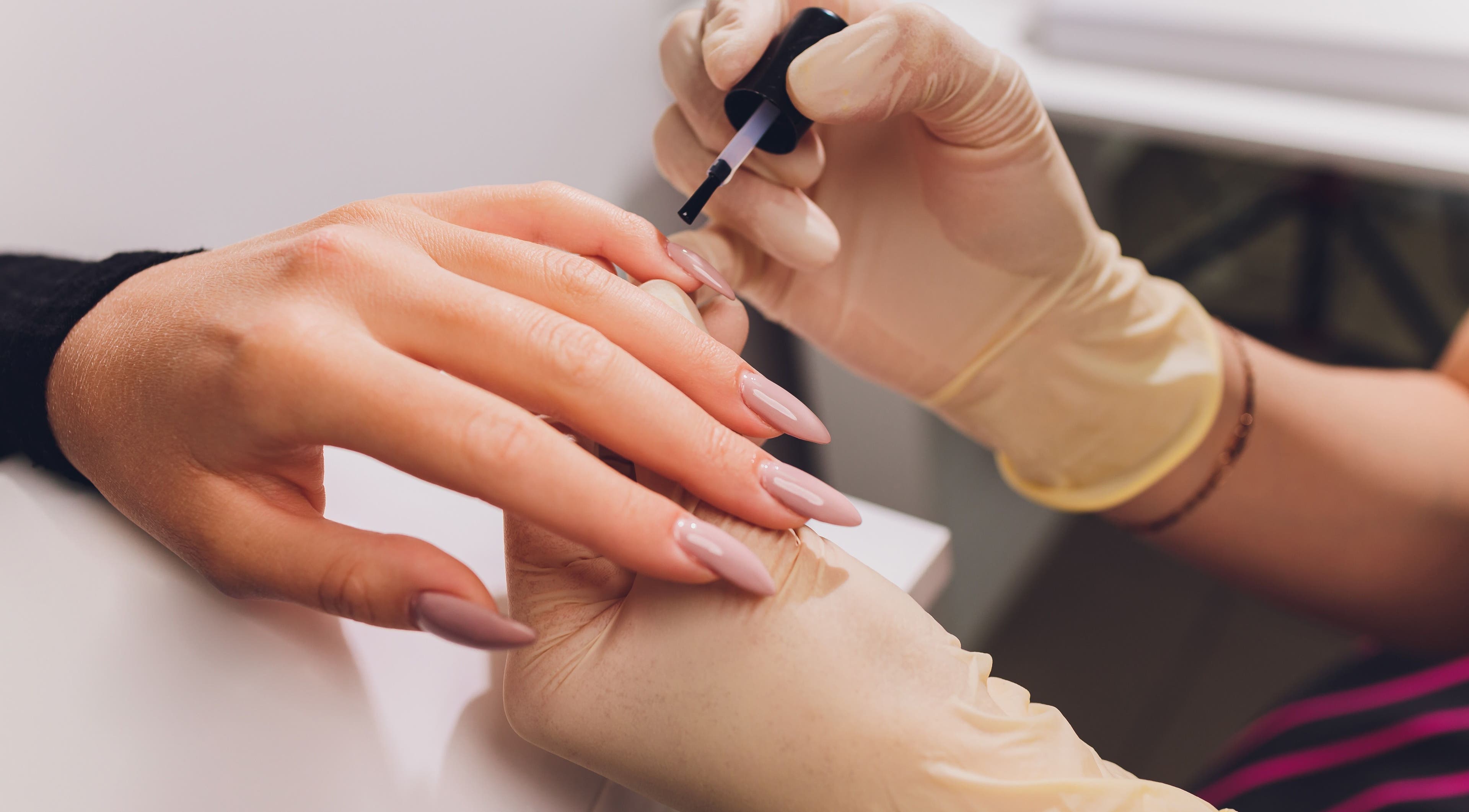 Nail technician applying polish at Auva Nails Home Service in Abu Dhabi, AE. Perfect for a polished finish.