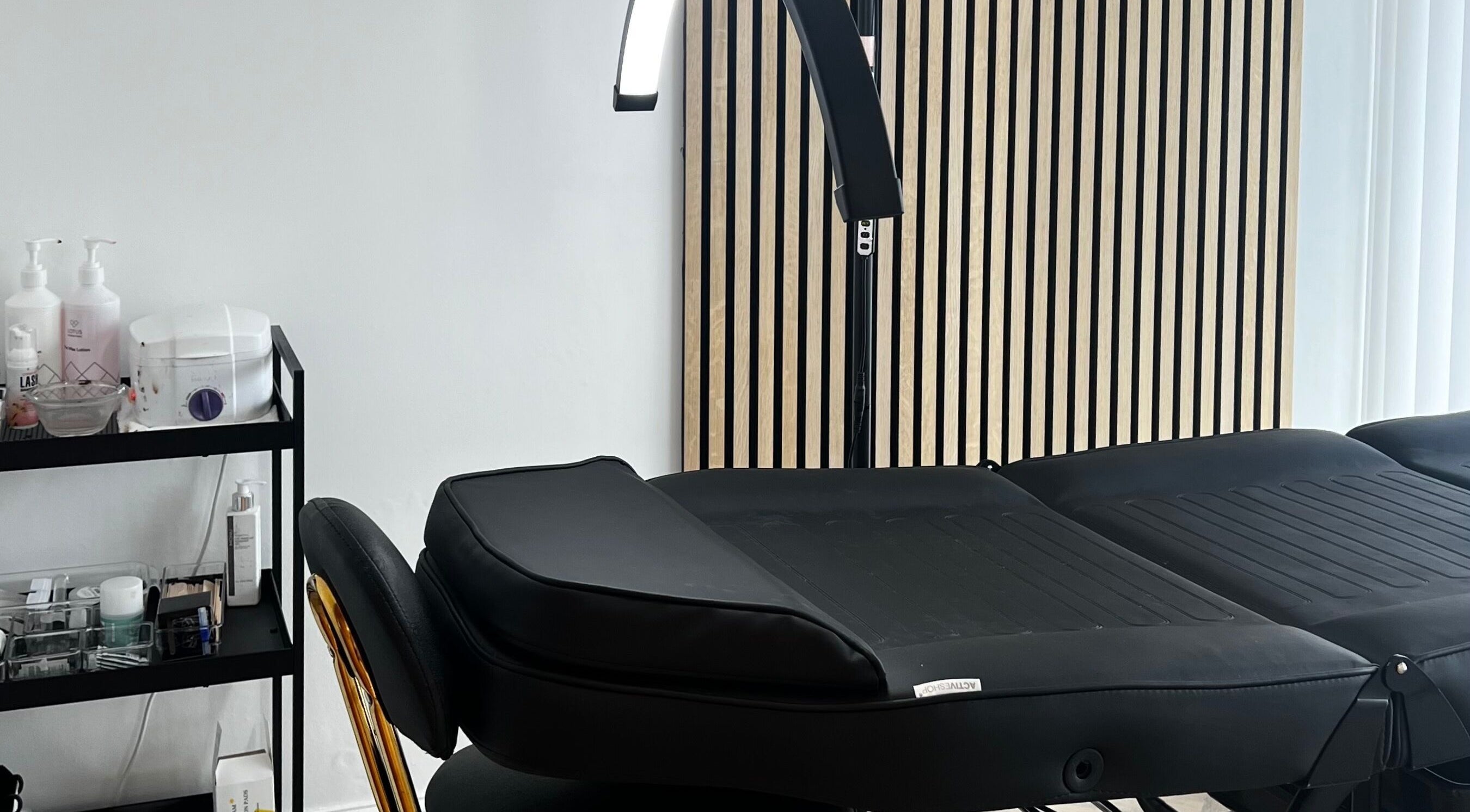 Pure Indulgence treatment room featuring a massage bed and products in Great Sankey, England, GB.