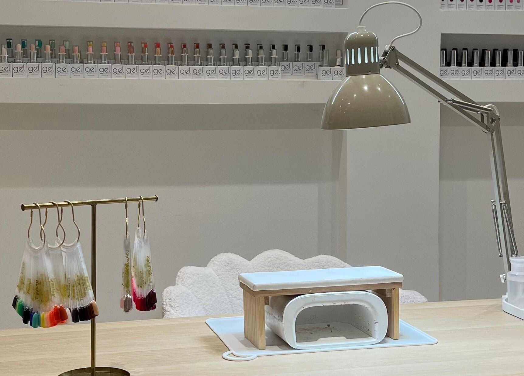 Nail art setup at Pure Indulgence, Great Sankey, England, GB, showcasing gel polish selection and UV lamp.