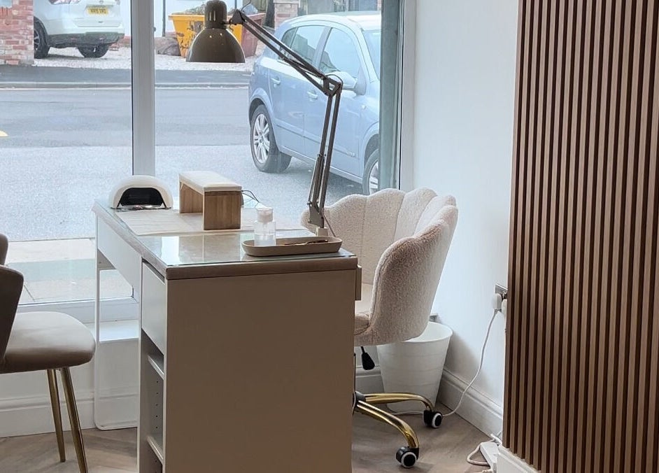 Luxurious nail salon station at Pure Indulgence, Great Sankey, England, GB with plush chairs and modern decor.