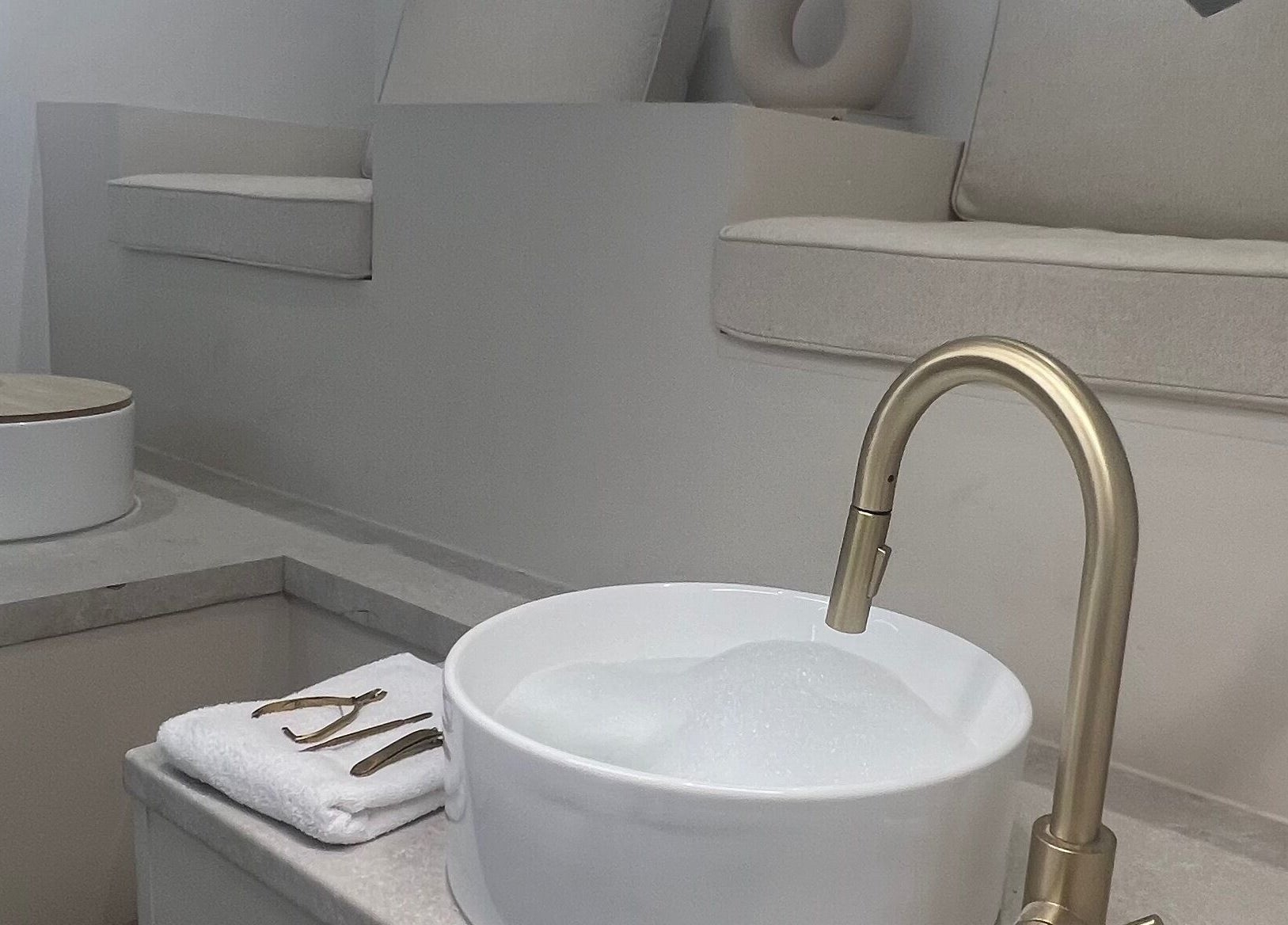 Luxurious foot spa setup at Pure Indulgence, Great Sankey, England, GB with gold faucet and plush seating.