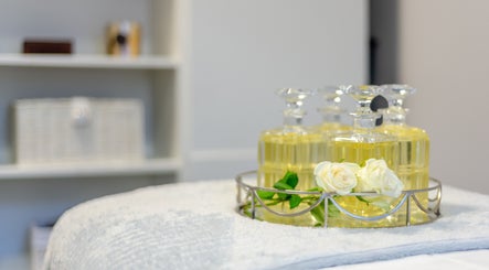 Essential oils and white roses at The House of Massage, London, England, GB, creating a serene atmosphere.