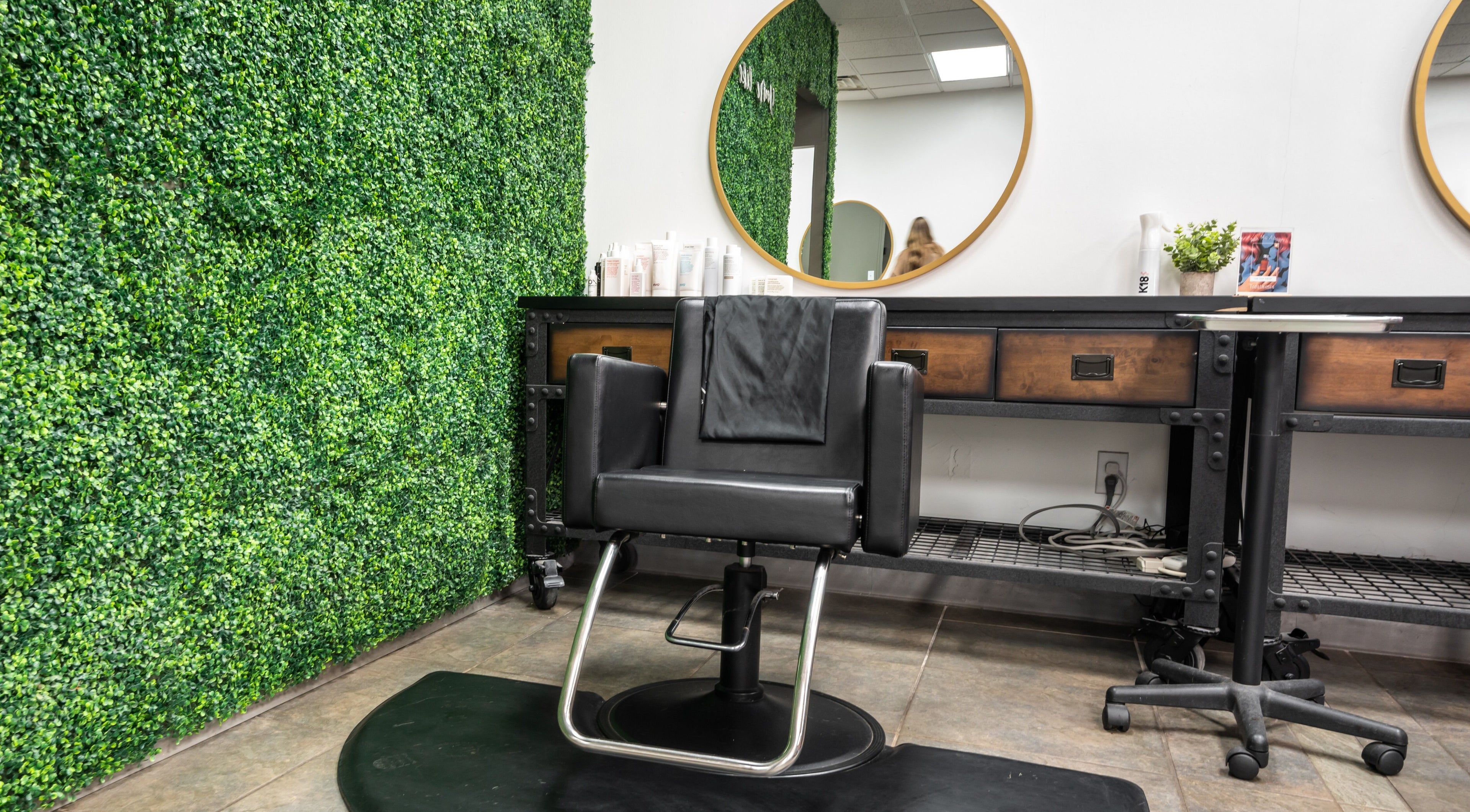 Elegant styling chair and mirror at Southern Hair Salon in Cartersville, Georgia, US with lush greenery decor.