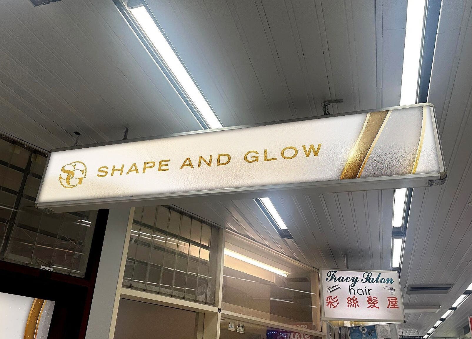 Illuminated sign for Shape and Glow, Blacktown, NSW, AU, under a modern, well-lit ceiling.