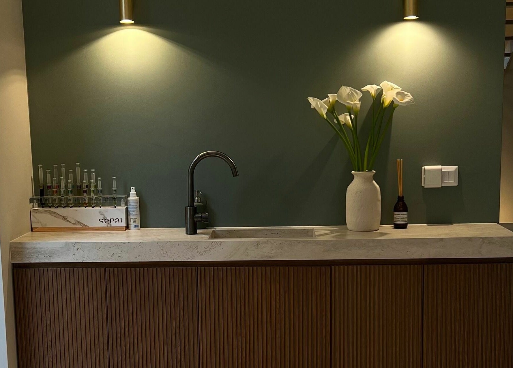 Chic sink setup with calla lilies at Face It Mind Skin Bar, Glifada, GR.