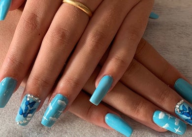 Uñas azules con diseño de mariposa y pedrería en ByBeauty, Sant Celoni, Catalunya, ES.
