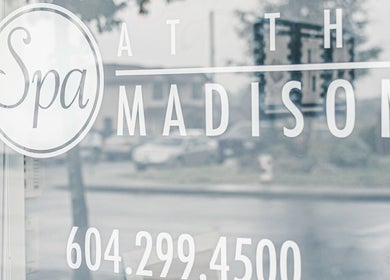Entrance sign of Spa at the Madison in Burnaby, British Columbia, CA on a reflective glass door.