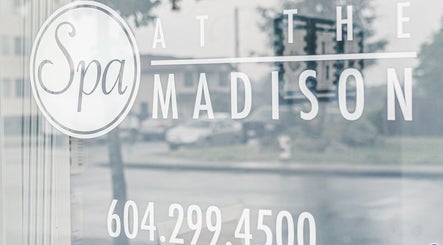 Entrance sign of Spa at the Madison in Burnaby, British Columbia, CA on a reflective glass door.