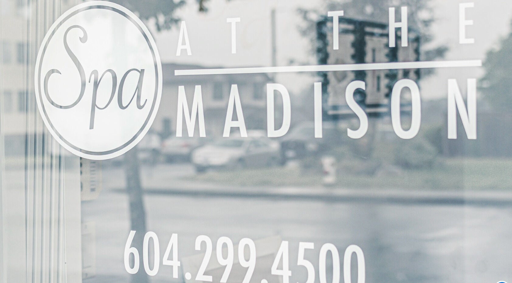 Front glass signage of Spa at the Madison in Burnaby, BC, CA showcasing elegant branding.