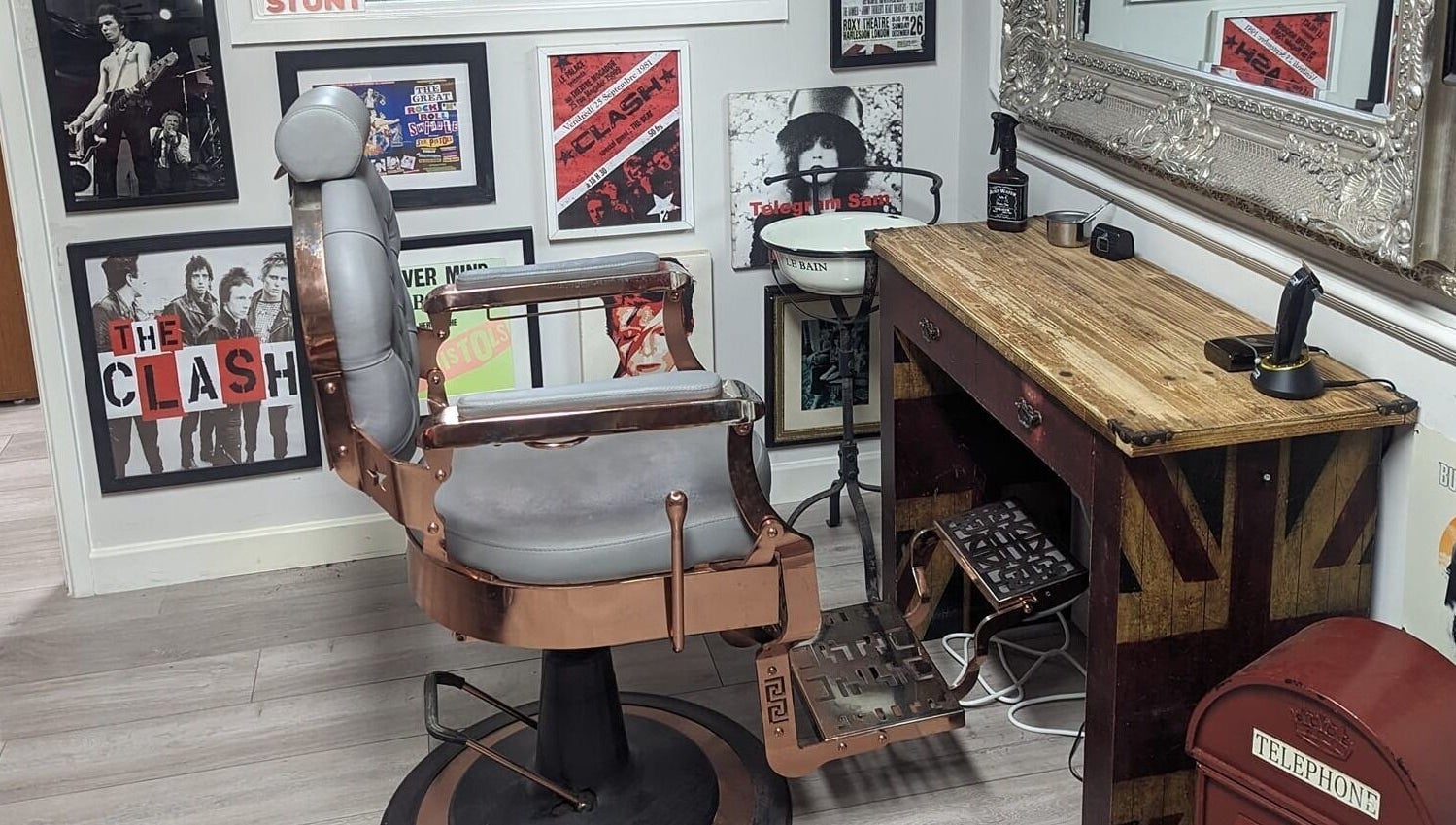 Stylish barber chair and rustic decor at Fred's Barbers, Crawley, England, GB flaunting vintage posters.