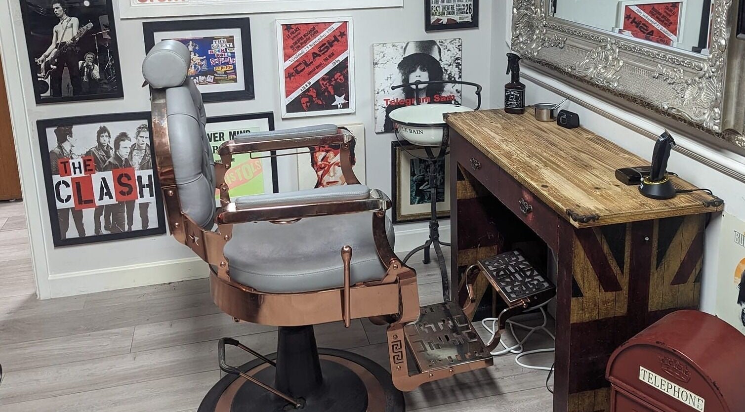 Stylish barber chair and rustic decor at Fred's Barbers, Crawley, England, GB flaunting vintage posters.