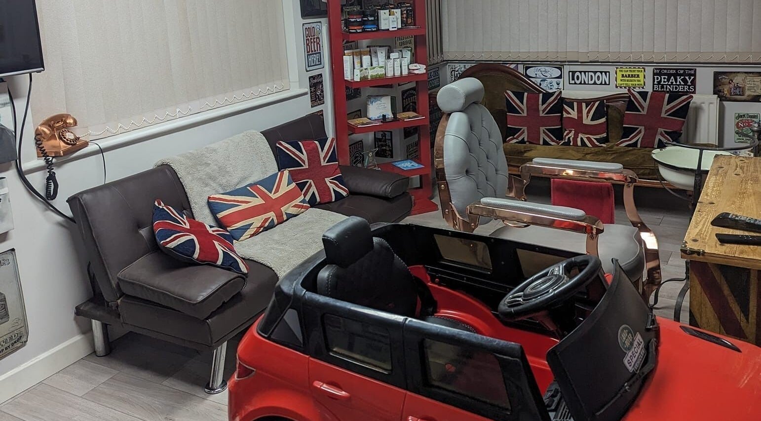 British-themed seating area at Fred's Barbers, Crawley, England, GB with Union Jack pillows.