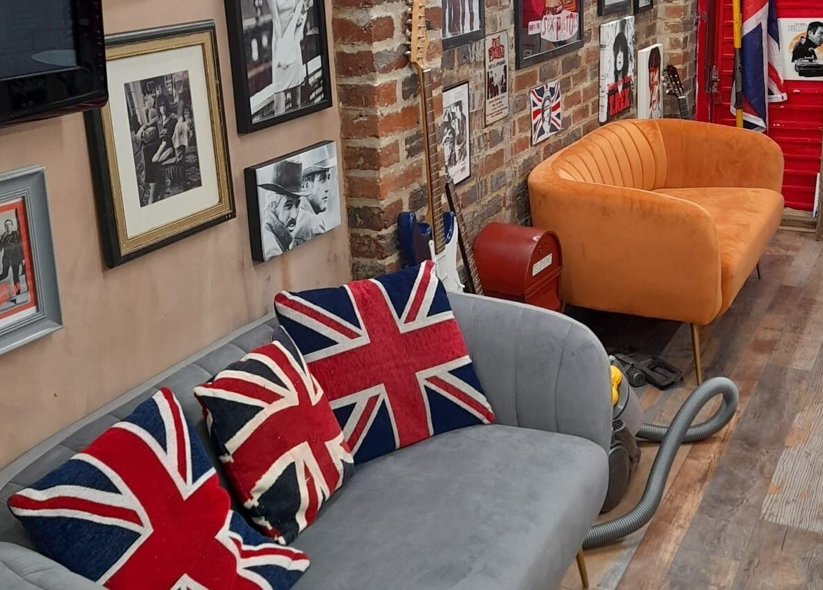 Fred's Barbers lounge with vintage decor and Union Jack cushions in Crawley, England, GB.