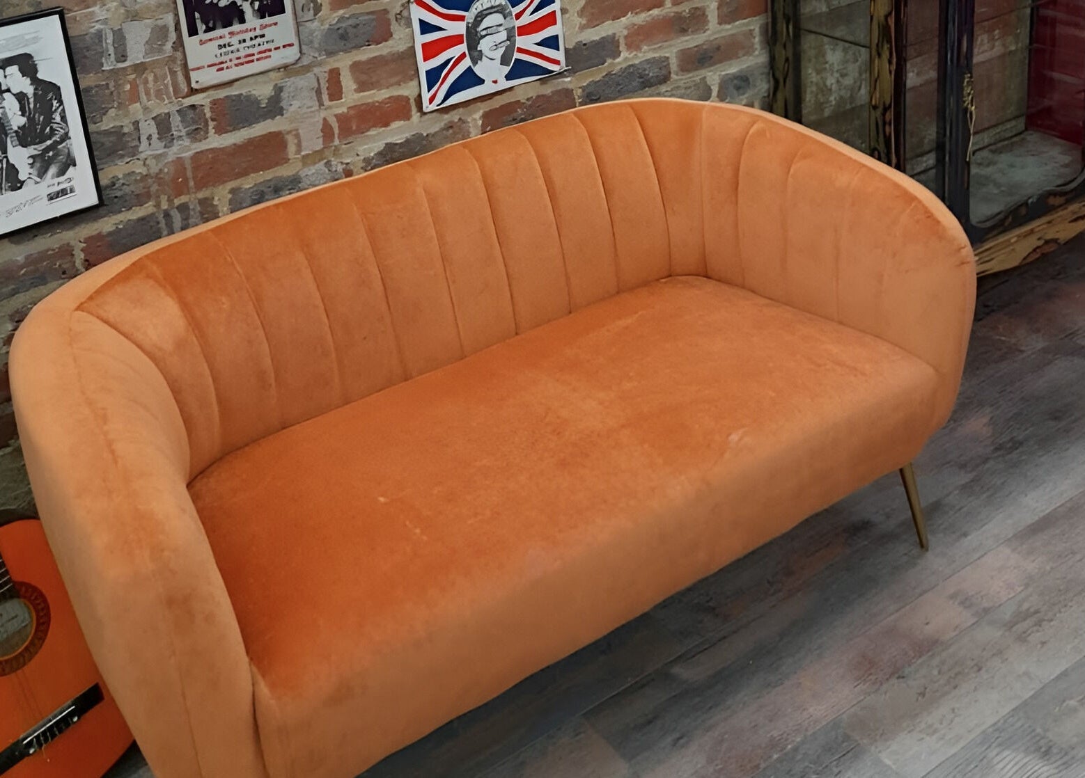 Vintage orange sofa with guitar decor at Fred's Barbers, Crawley, England, GB.