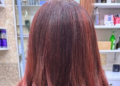 Glossy red hair treatment at Moon Valley Shine Spa - Home Service, Dubai, AE showcasing vibrant color in a salon setting.