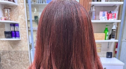 Glossy red hair treatment at Moon Valley Shine Spa - Home Service, Dubai, AE showcasing vibrant color in a salon setting.