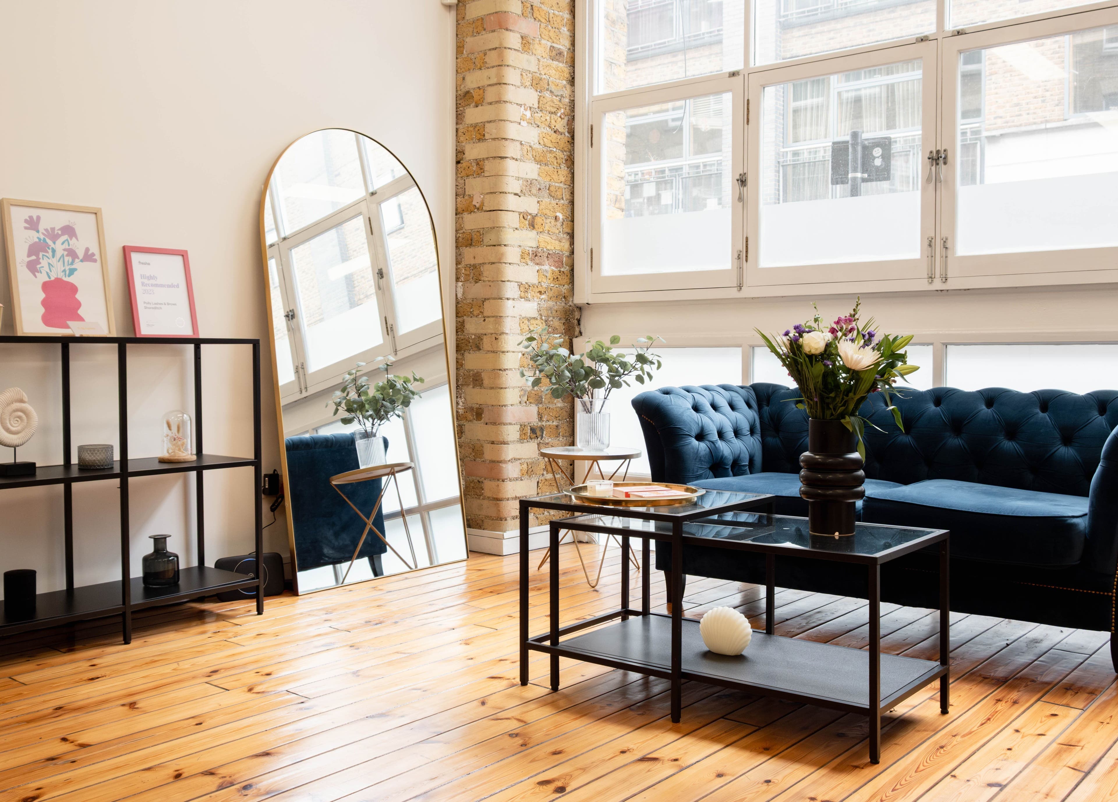 Chic lounge at Polly Lashes & Brows London, England, GB with plush sofa and modern decor.