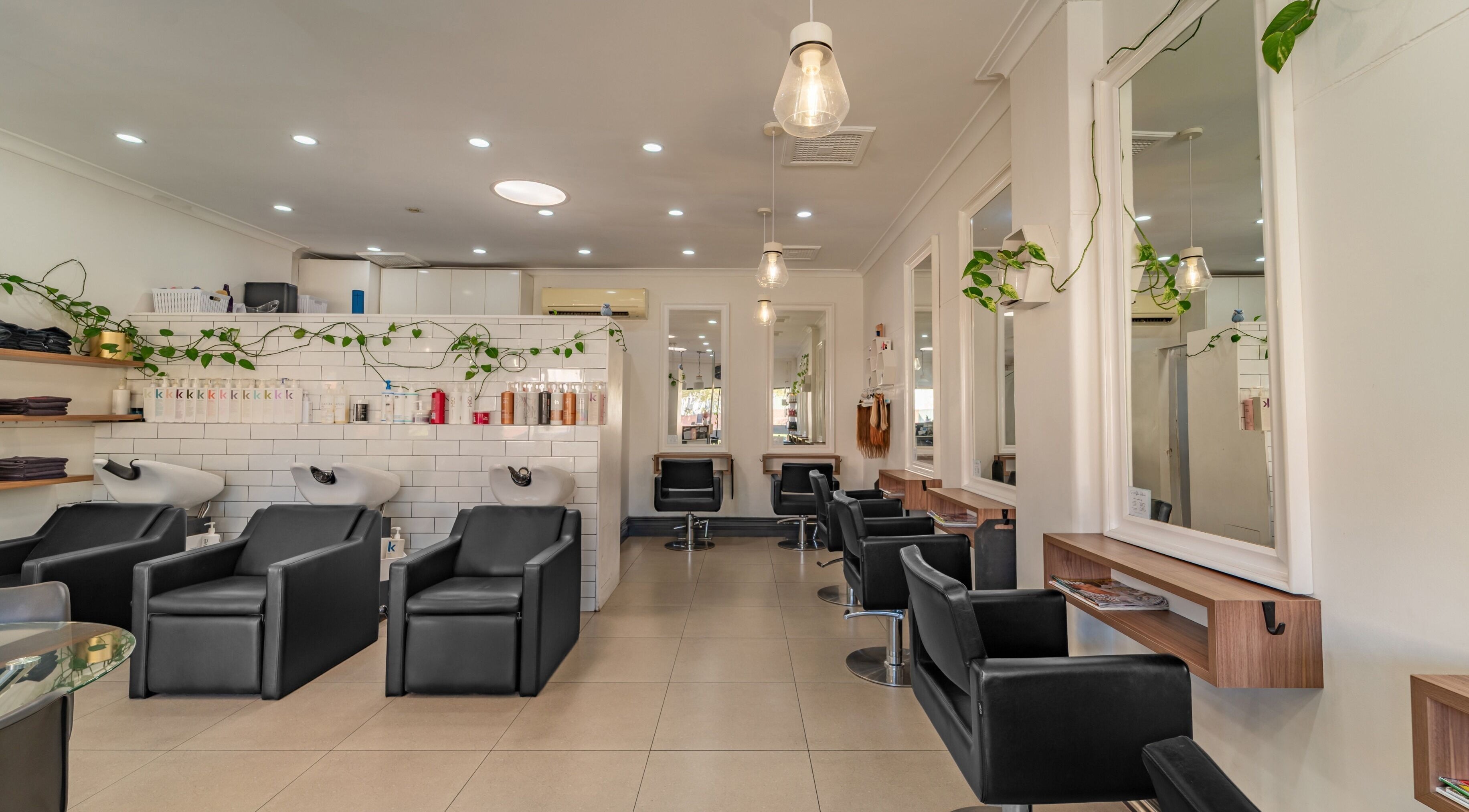 Chic interior of Spoilt Hair Retreat, Wembley, Western Australia with stylish black salon chairs and mirrors.