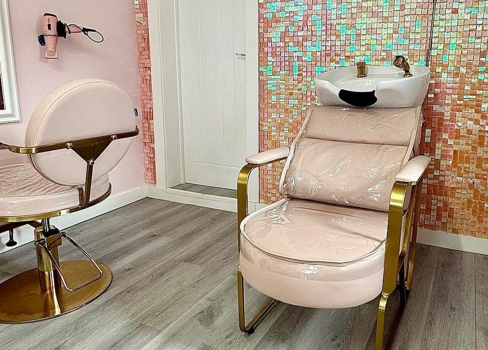 Lux Locks by Edie salon interior in Bexhill, England, GB featuring a pink styling chair and vibrant mosaic wall.