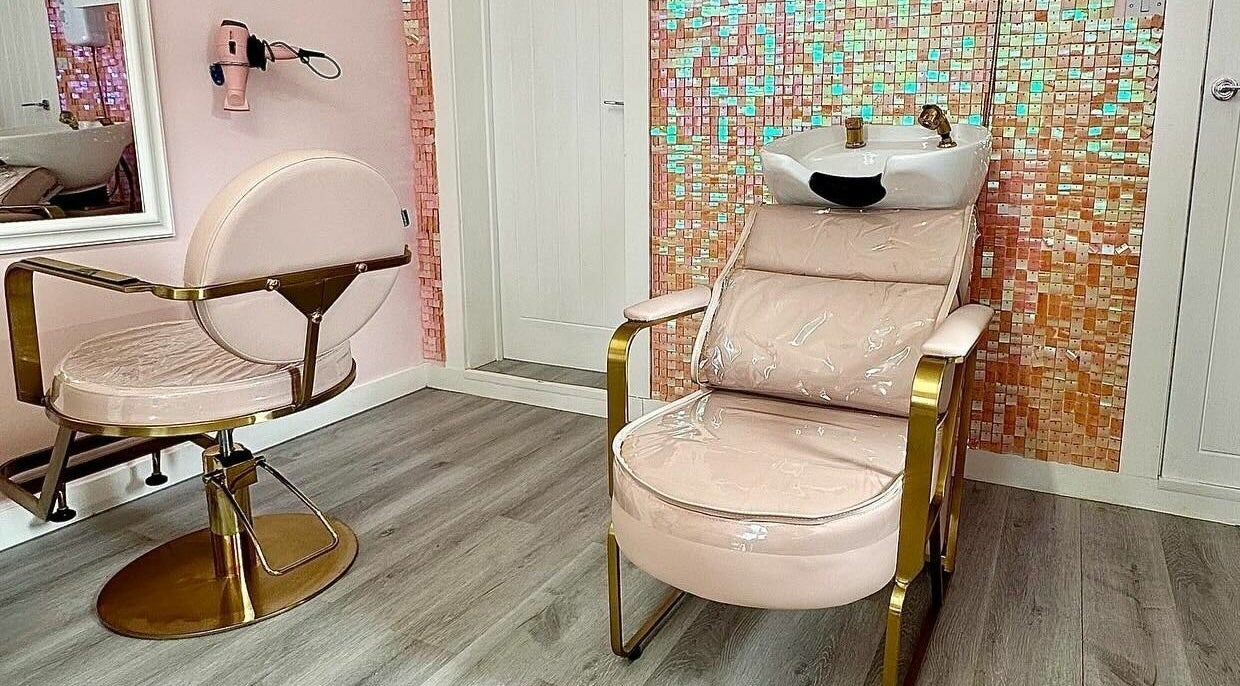 Lux Locks by Edie salon interior in Bexhill, England, GB featuring a pink styling chair and vibrant mosaic wall.