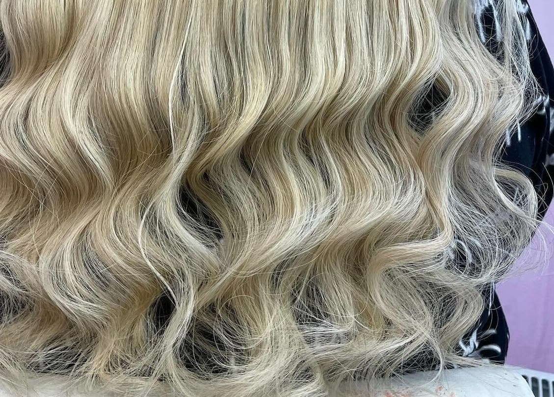 Lux Locks by Edie in Bexhill, England presents flowing blonde waves in a serene salon setting.