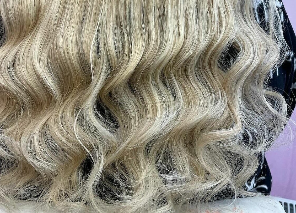 Lux Locks by Edie in Bexhill, England presents flowing blonde waves in a serene salon setting.