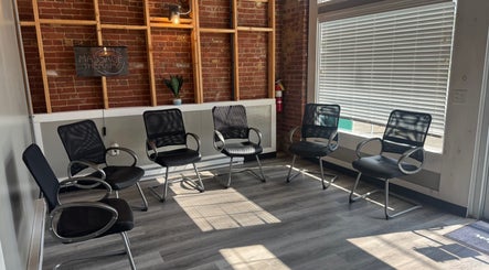Modern waiting area at Kingston Body Wellness, Kingston, Georgia, US, featuring stylish black chairs.