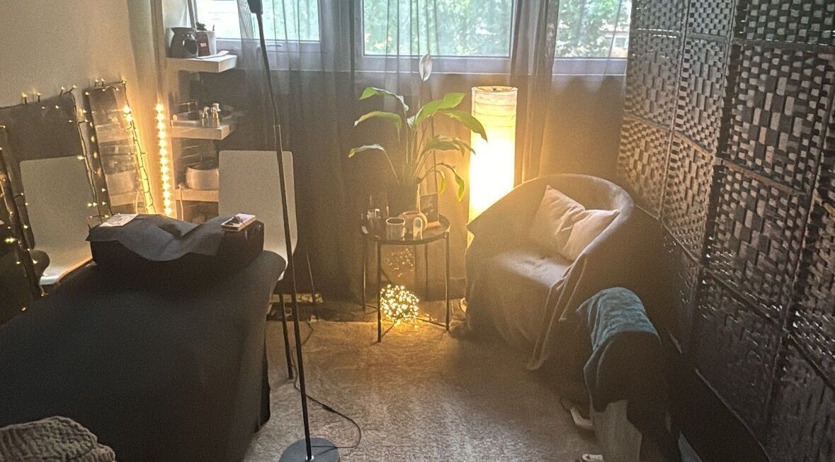 Cozy treatment room at Beauty Izz, Fullers Slade, England, GB with warm lighting and comfortable seating.