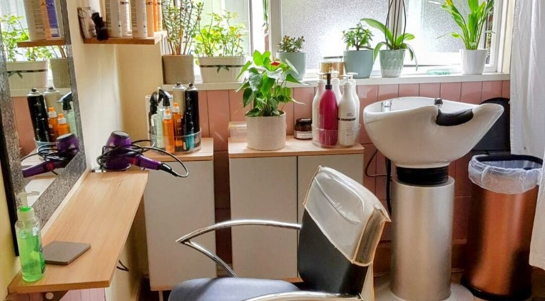 Chic styling station at Hair by Elena P in London, England, GB, with plants and hair products.