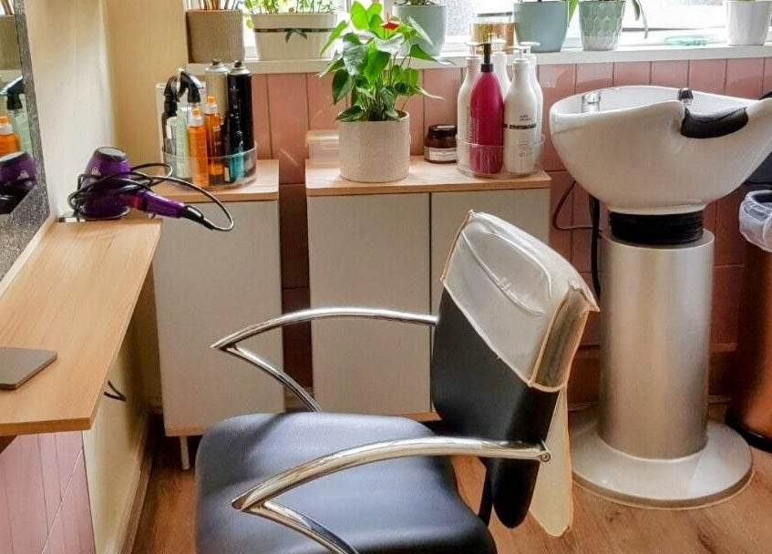 Stylish salon interior at Hair by Elena P in London, England, GB featuring a modern chair and washing station.