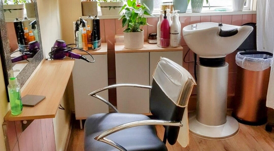 Stylish salon interior at Hair by Elena P in London, England, GB featuring a modern chair and washing station.
