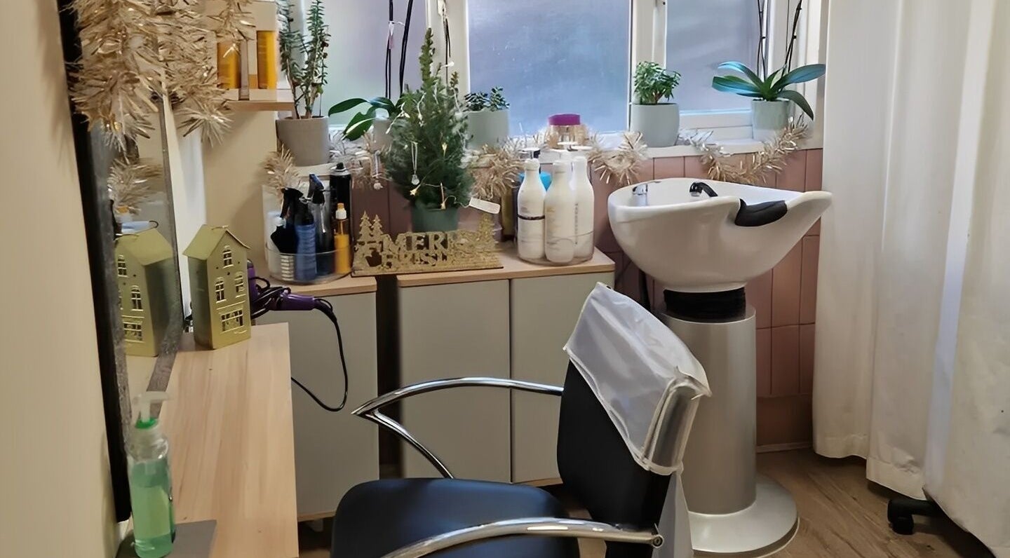 Stylish salon interior at Hair by Elena P in London, England, GB with a hair washing station and decor.