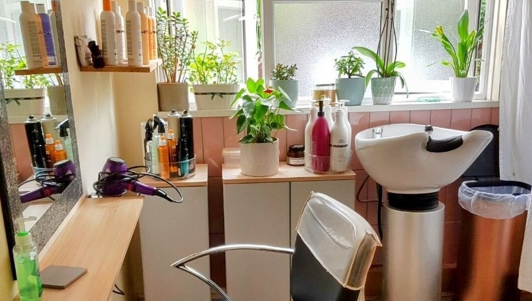 Cozy setup at Hair by Elena P in London, England, GB with styling products and greenery.