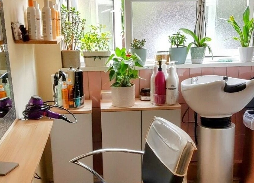 Cozy setup at Hair by Elena P in London, England, GB with styling products and greenery.