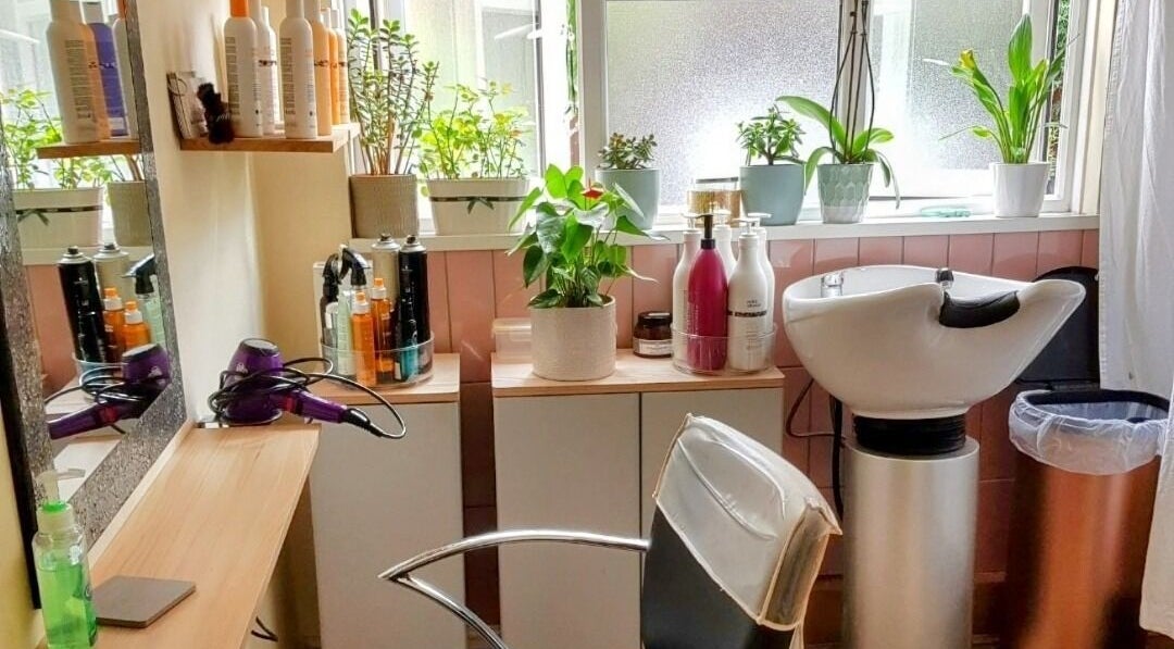 Cozy setup at Hair by Elena P in London, England, GB with styling products and greenery.
