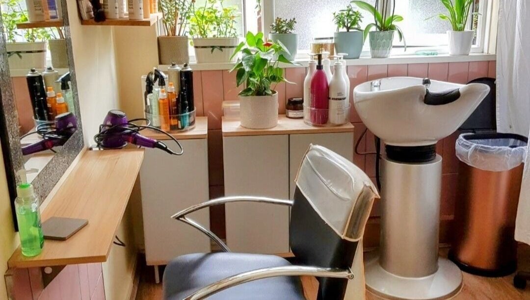 Modern styling station at Hair by Elena P in London, England, GB with plants and beauty products.
