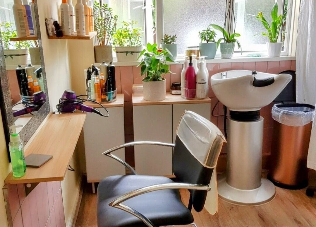 Modern styling station at Hair by Elena P in London, England, GB with plants and beauty products.