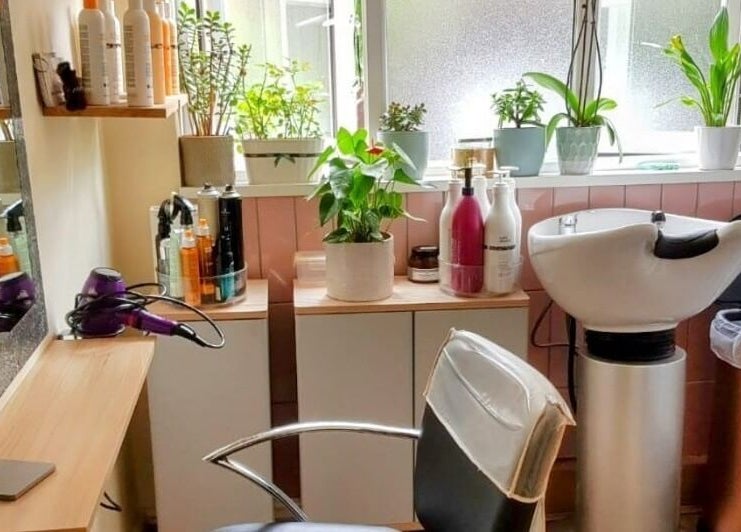 Modern salon station at Hair by Elena P in London, England, GB with plants and stylish hair products.