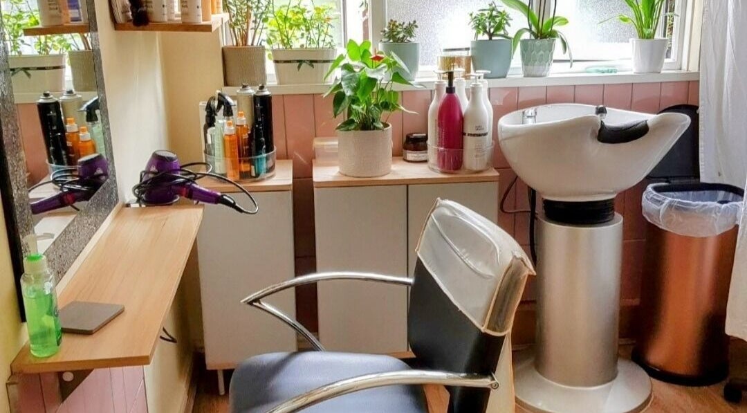 Chic hairdressing station at Hair by Elena P, London, England, GB, featuring modern chair and lush plants.