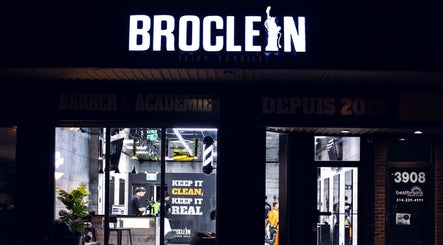Vue extérieure nocturne de Broclean Barbershop à Longueuil, Québec, CA avec enseigne lumineuse.