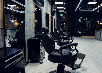 Intérieur moderne de Broclean Barbershop, Longueuil, Québec, CA, montrant des fauteuils élégants et décor contemporain.