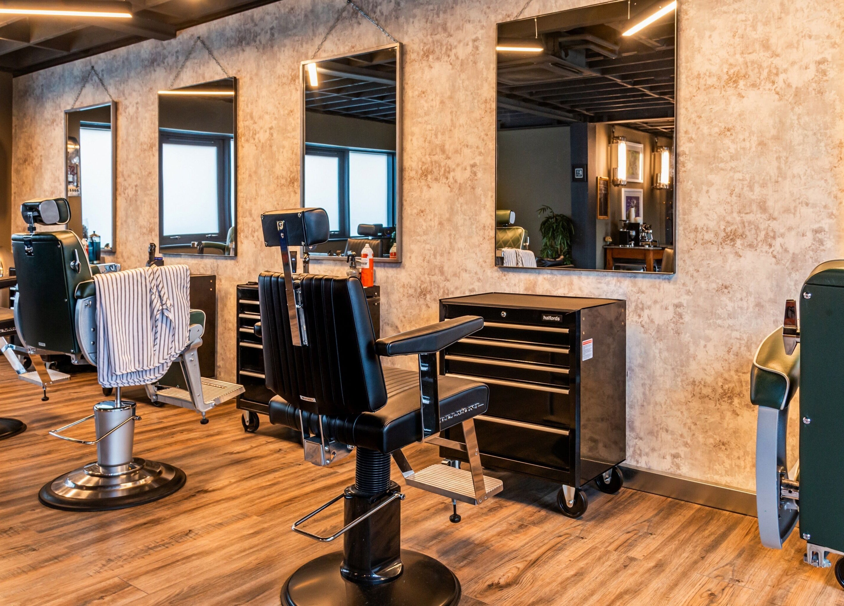 Modern barber chairs and mirrors at Boilerhouse Gentleman - Ouseburn in Newcastle upon Tyne, England, GB.