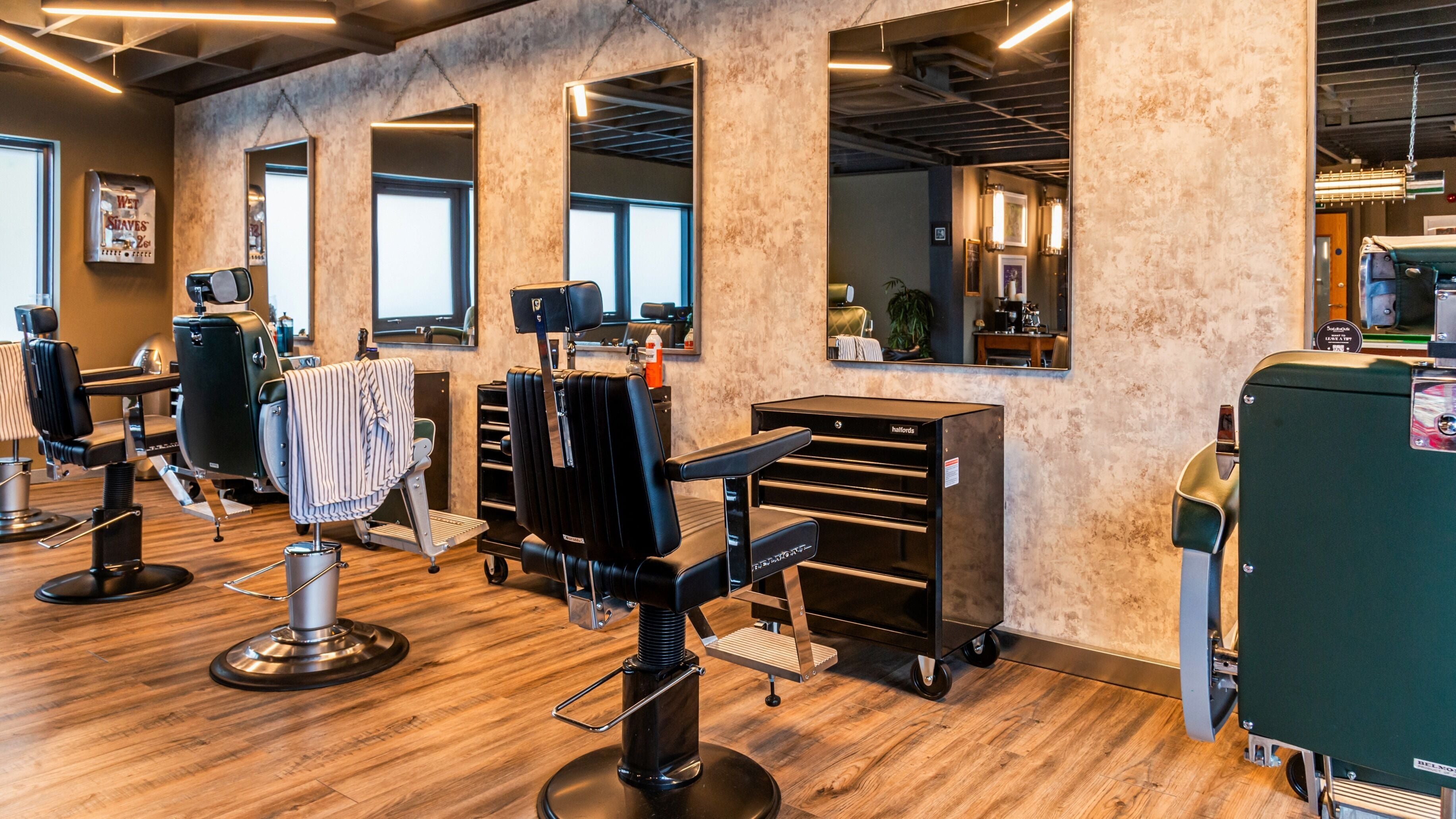 Modern barber chairs and mirrors at Boilerhouse Gentleman - Ouseburn in Newcastle upon Tyne, England, GB.