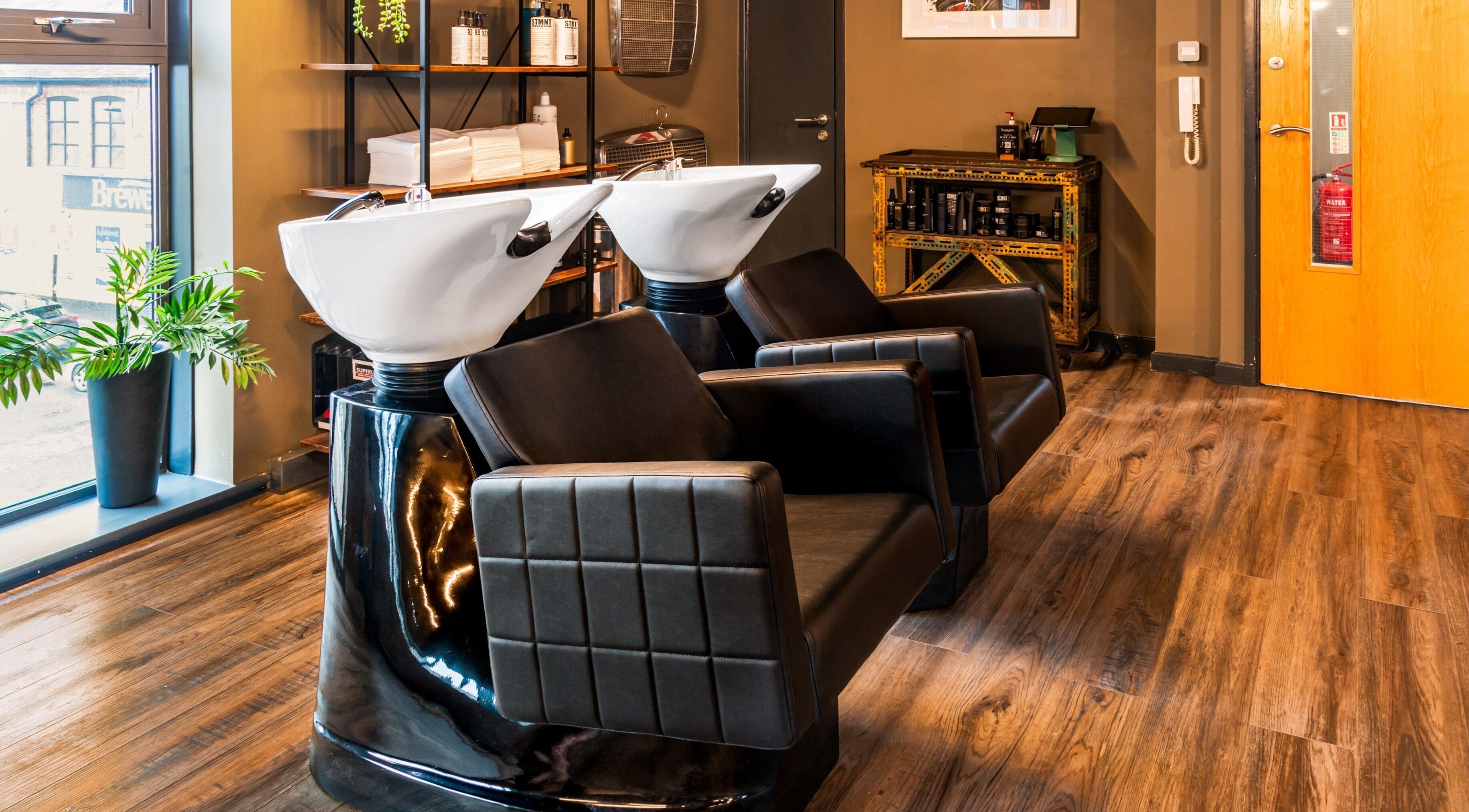 Modern wash stations at Boilerhouse Gentleman - Ouseburn, Newcastle upon Tyne, England, GB. Sleek black leather seating.